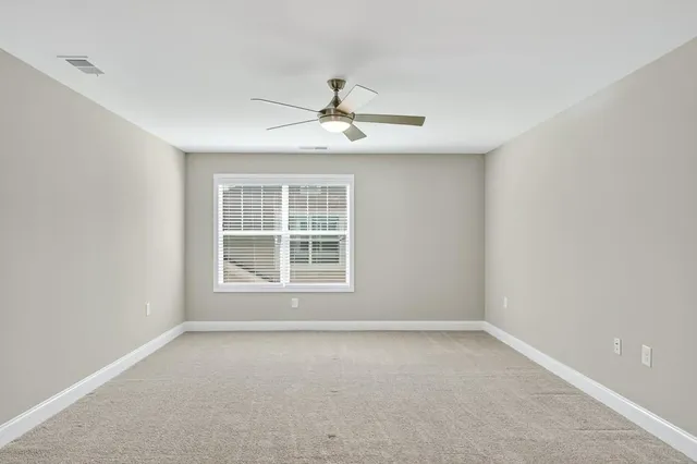 an empty room with a window and a fan
