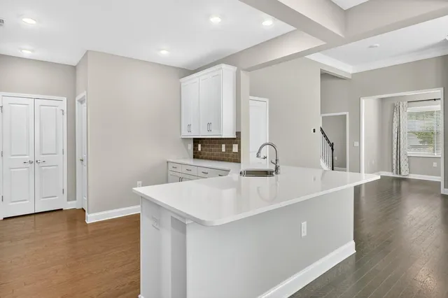a large white kitchen with wooden floor