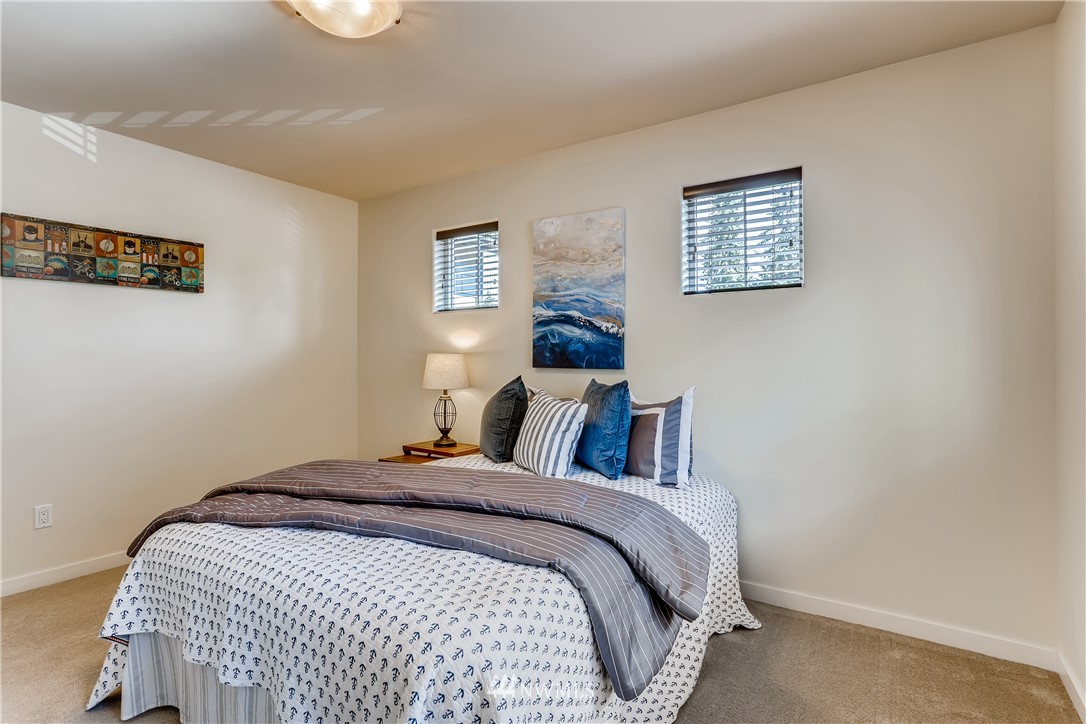 9 233rd Place Southeast Bothell, WA 98021 - Photo 22 of 36 a bed sitting in a bedroom next to a lamp