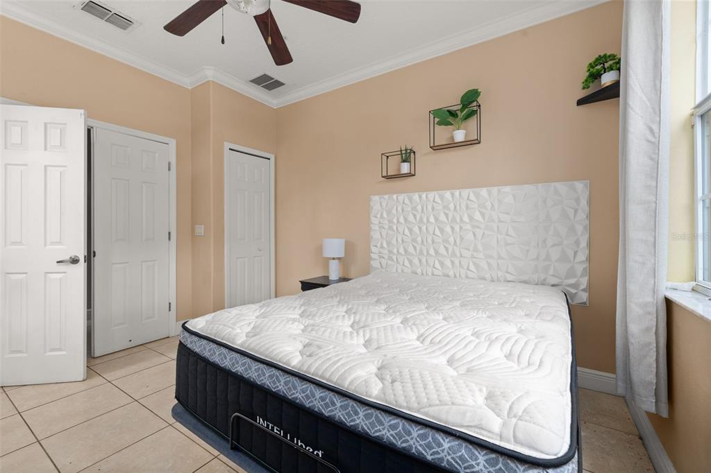 811 Assembly Court Reunion, FL 34747 - Photo 19 of 84 a bedroom with a bed and a painting on the wall