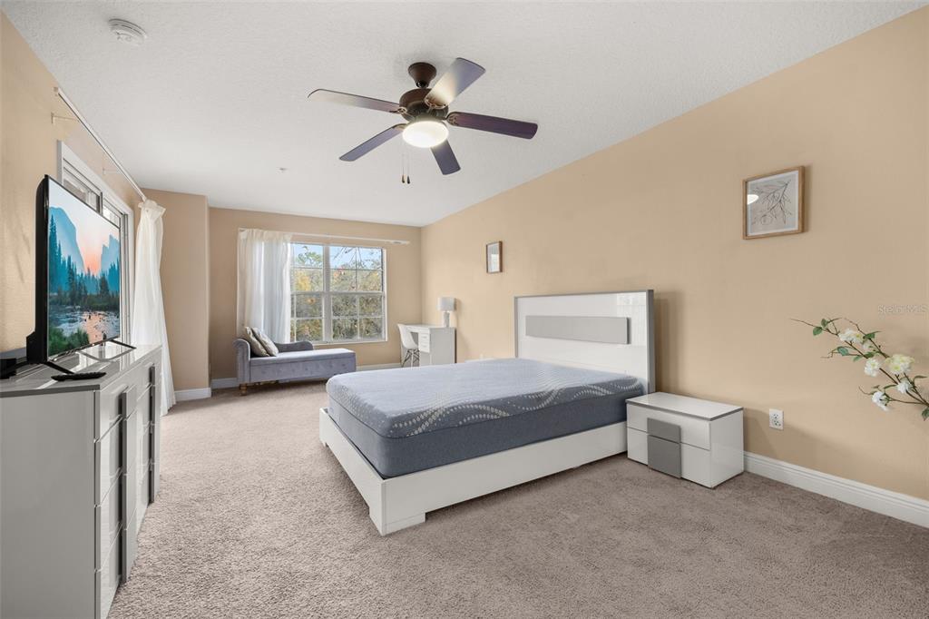 811 Assembly Court Reunion, FL 34747 - Photo 30 of 84 a spacious bedroom with a large bed and a flat screen tv
