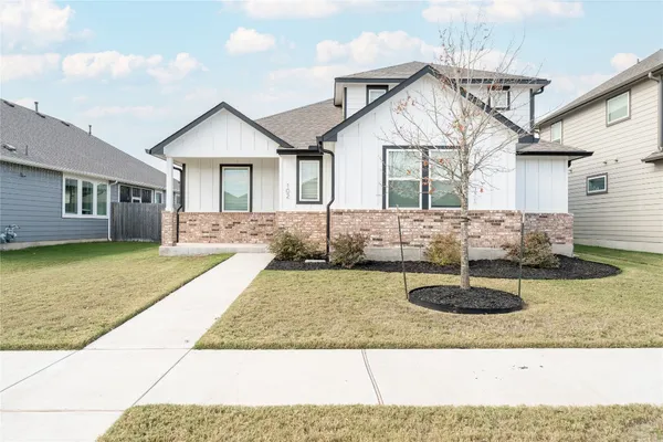 a view of a house with backyard and sitting area