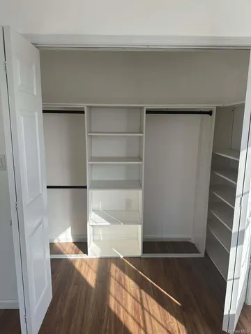 a view of walk in closet with empty racks
