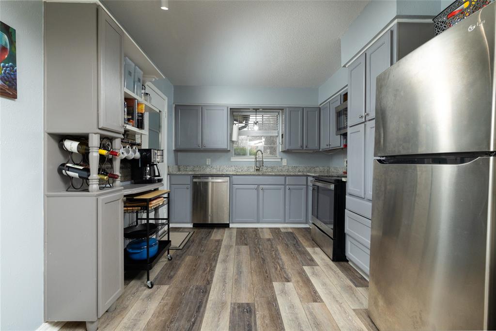 6020 Harrison Way Watauga, TX 76148 - Photo 15 of 32 a kitchen with a refrigerator cabinets and wooden floor