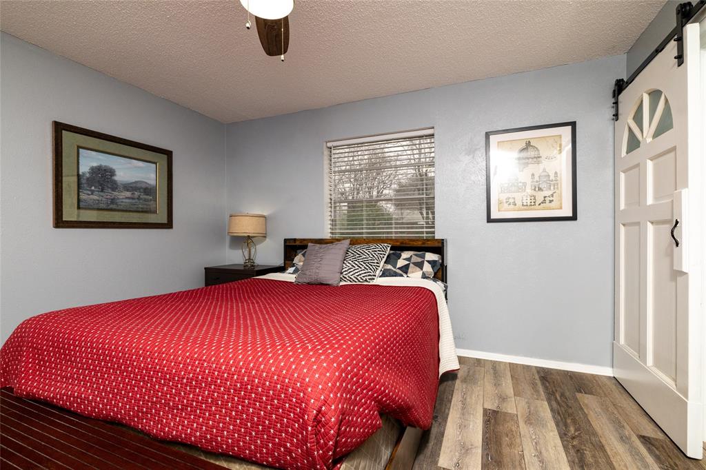 6020 Harrison Way Watauga, TX 76148 - Photo 21 of 32 a bedroom with a bed and a painting on the wall