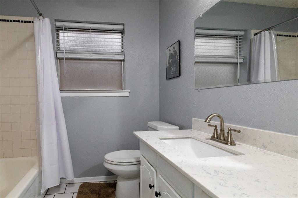 6020 Harrison Way Watauga, TX 76148 - Photo 26 of 32 a bathroom with a granite countertop sink toilet and mirror
