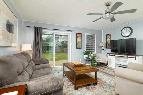 a living room with furniture a flat screen tv and a large window
