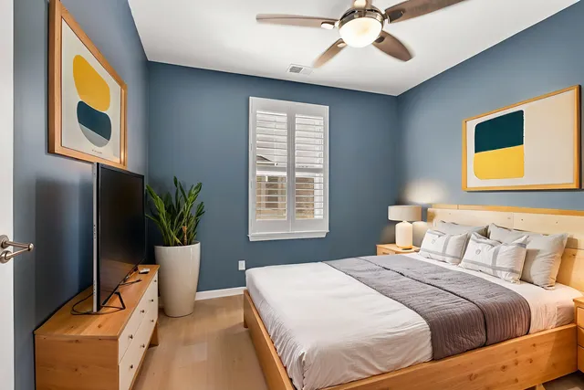 a bedroom with a bed and a potted plant