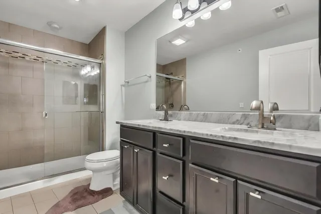 a bathroom with a granite countertop sink a toilet and a mirror