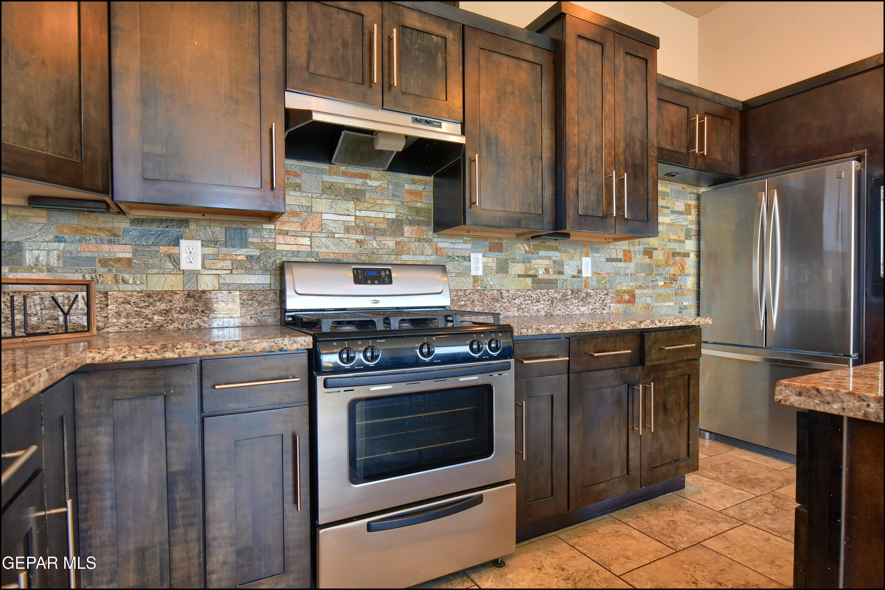401 Ana Way, Unit B El Paso, TX 79912 - Photo 14 of 54 a kitchen with stainless steel appliances granite countertop wooden cabinets stove top oven and sink