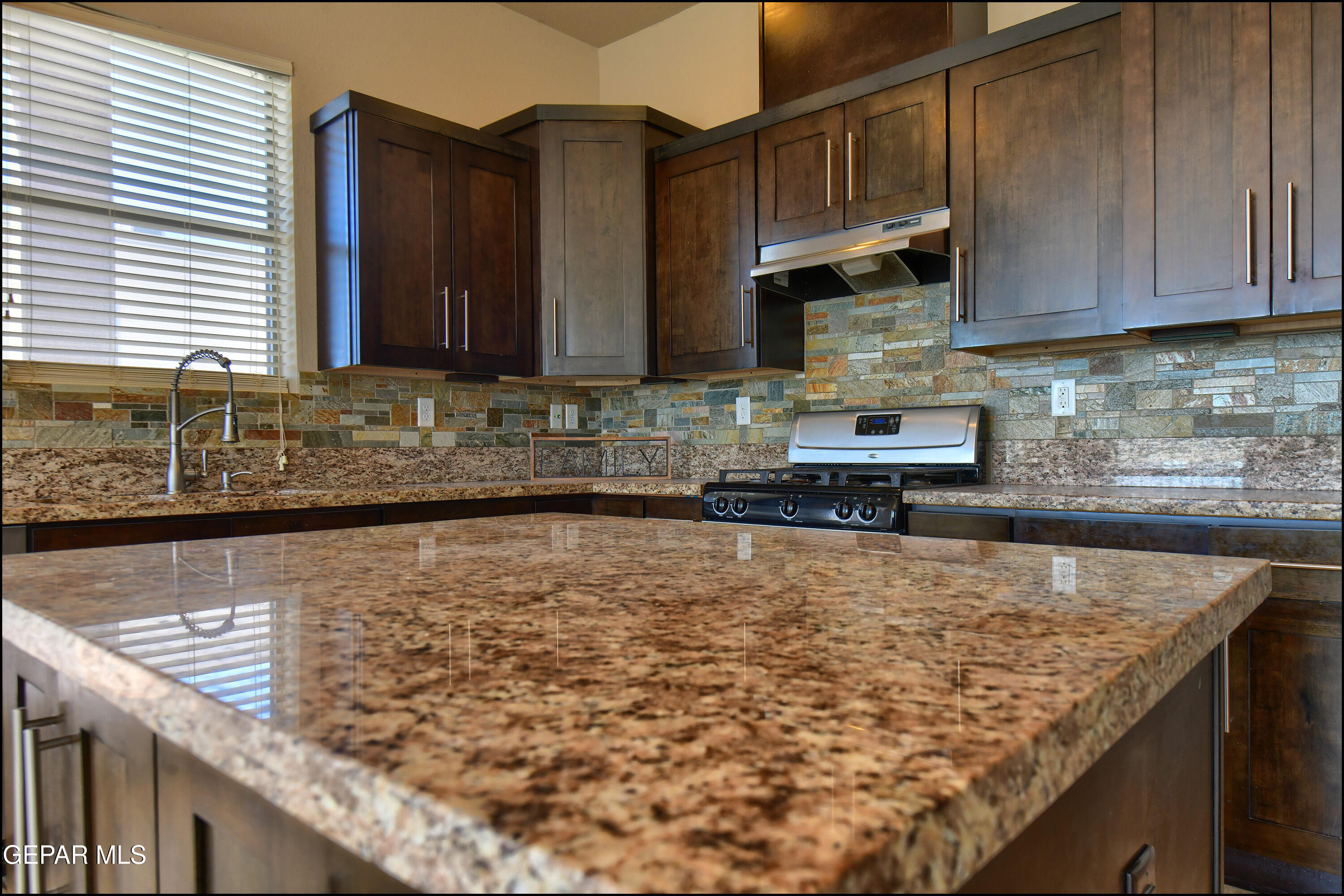 401 Ana Way, Unit B El Paso, TX 79912 - Photo 18 of 54 a kitchen with kitchen island granite countertop a sink a stove and cabinets
