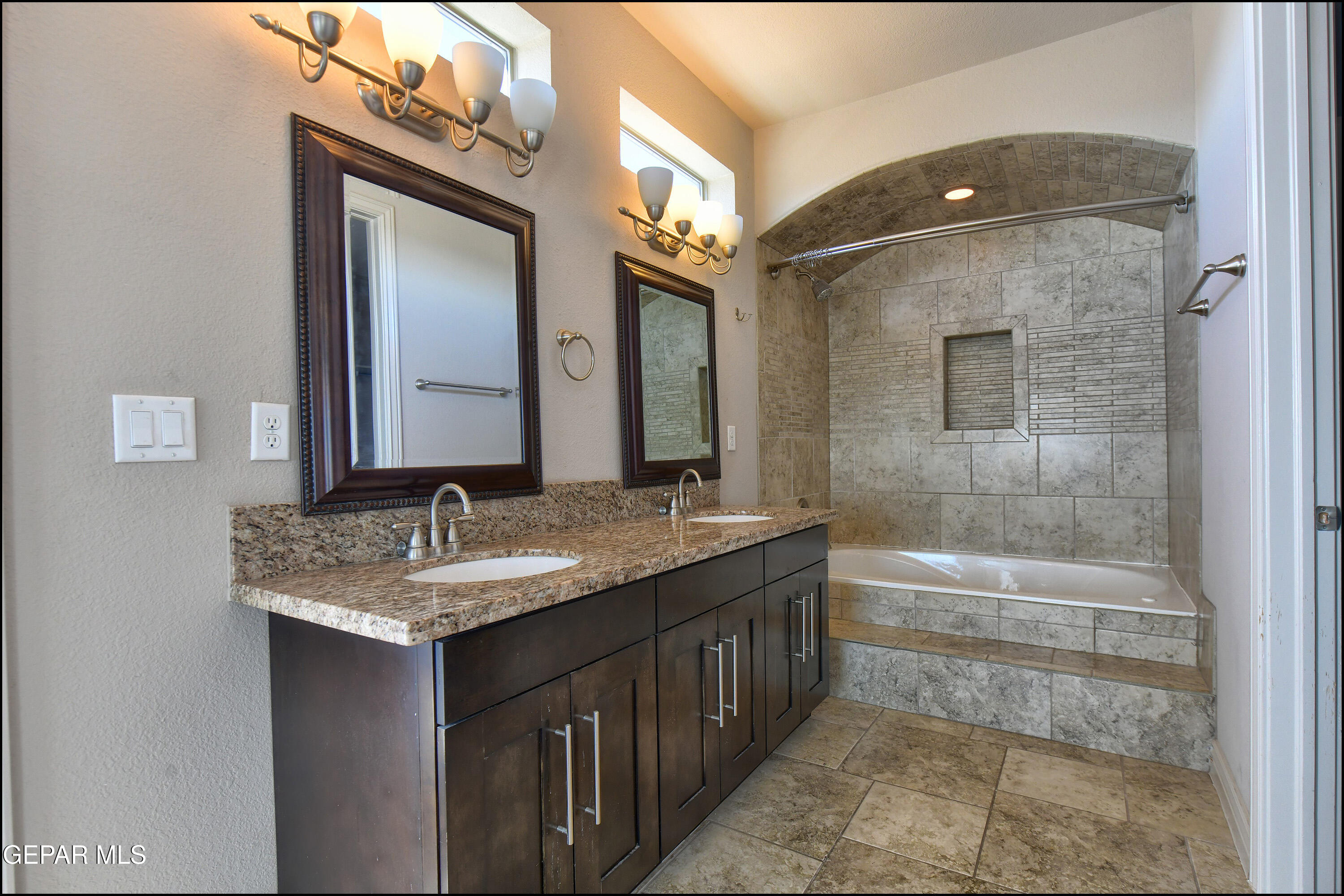 401 Ana Way, Unit B El Paso, TX 79912 - Photo 24 of 54 a bathroom with a granite countertop sink mirror and a bathtub