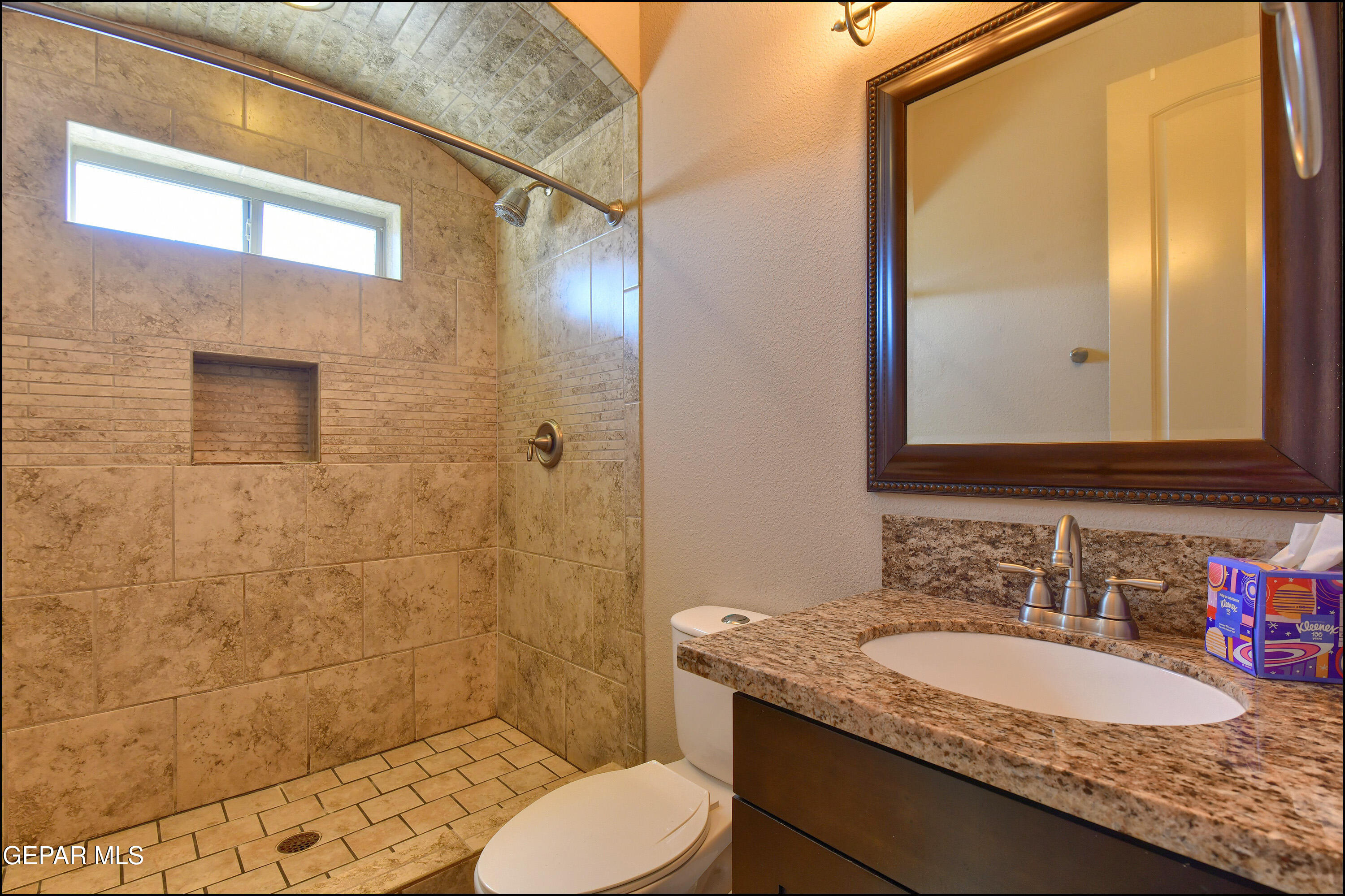 401 Ana Way, Unit B El Paso, TX 79912 - Photo 35 of 54 a bathroom with a granite countertop sink toilet a mirror and shower