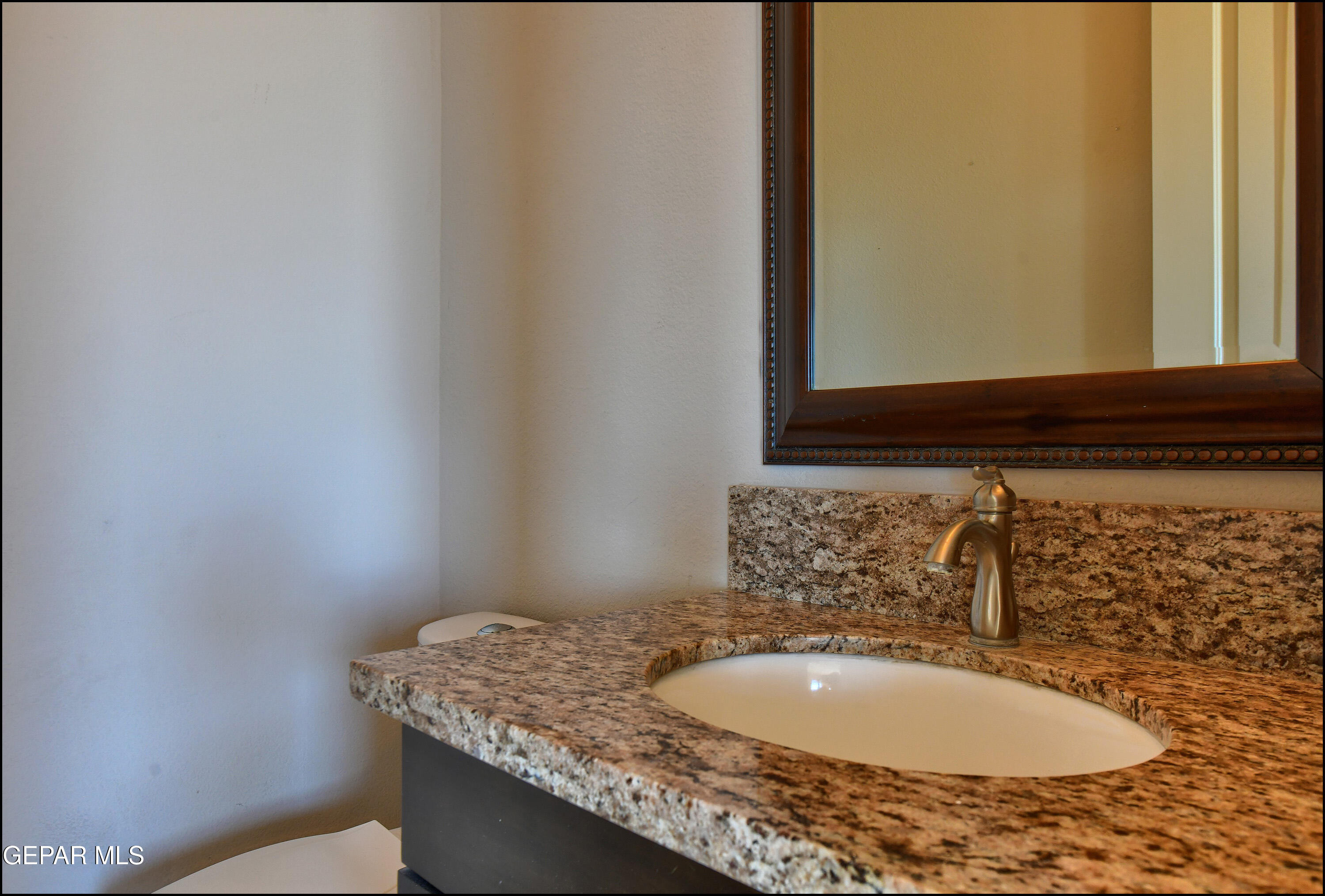 401 Ana Way, Unit B El Paso, TX 79912 - Photo 42 of 54 a bathroom with a granite countertop sink and a mirror