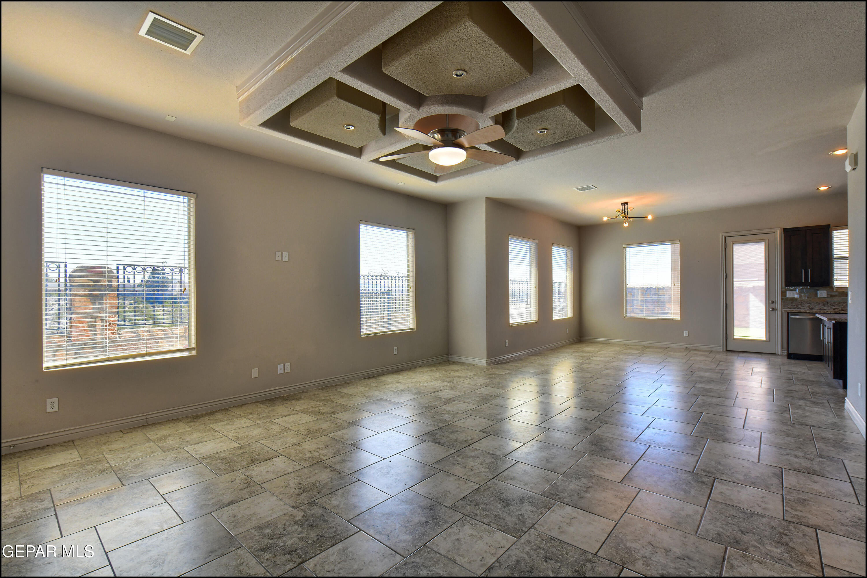 401 Ana Way, Unit B El Paso, TX 79912 - Photo 6 of 54 a view of an empty room with chandelier fan and windows