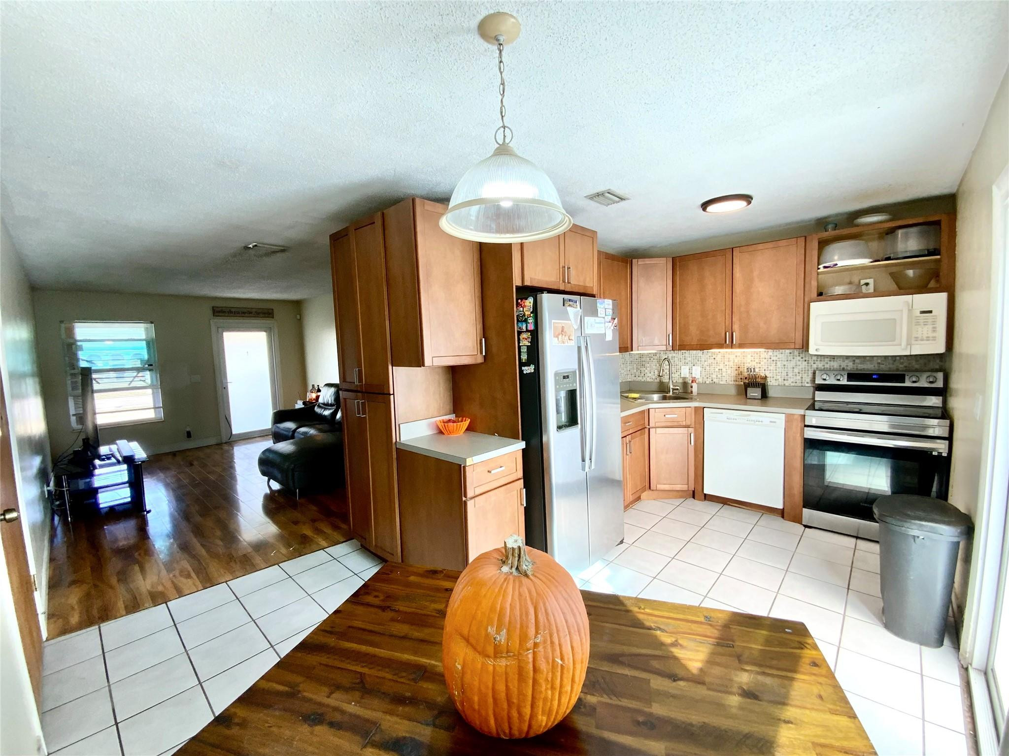 8160 Southwest 6th Street North Lauderdale, FL 33068 - Photo 13 of 39 a kitchen with stainless steel appliances kitchen island granite countertop a stove refrigerator and cabinets