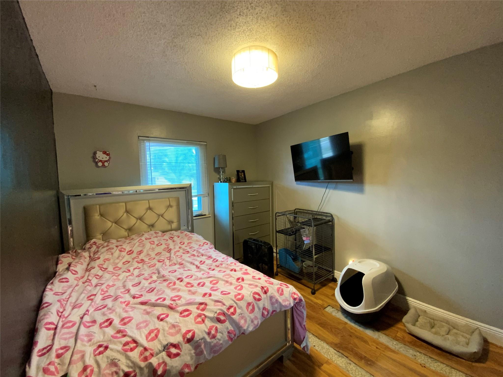 8160 Southwest 6th Street North Lauderdale, FL 33068 - Photo 18 of 39 a bedroom with a bed and a flat tv screen on dresser