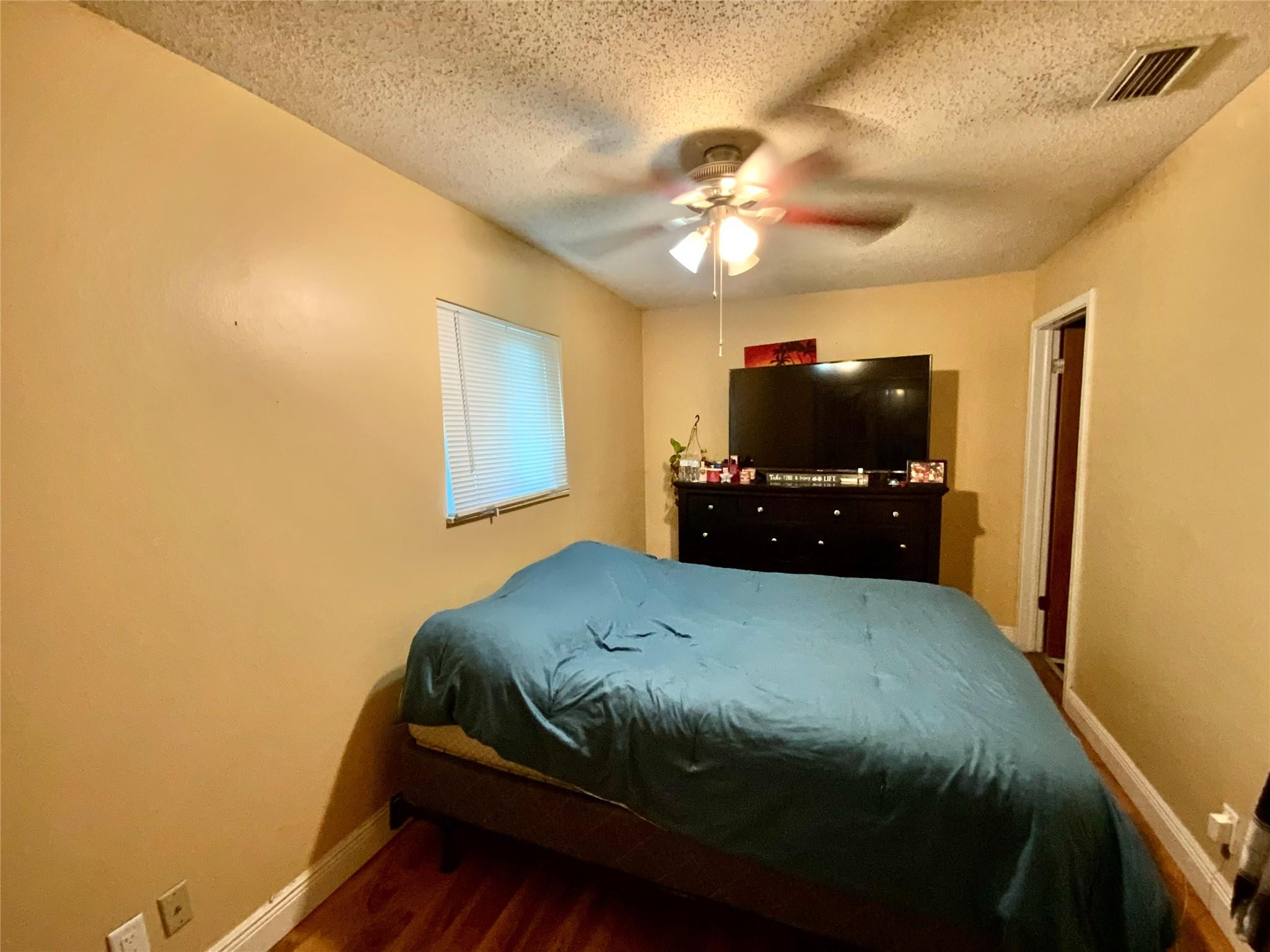 8160 Southwest 6th Street North Lauderdale, FL 33068 - Photo 20 of 39 a bedroom with a bed and a flat tv screen on dresser