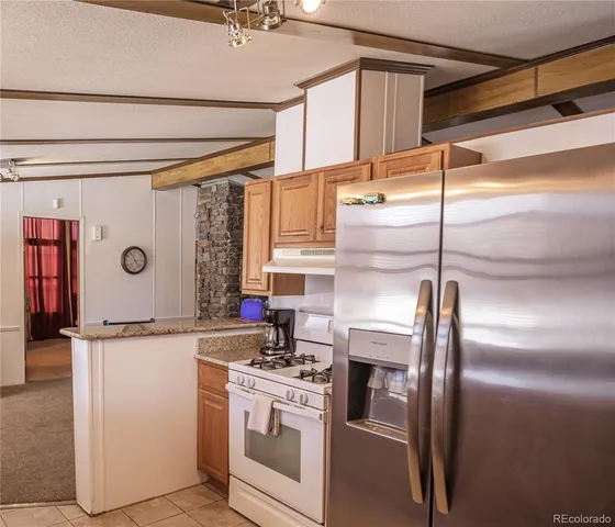 a kitchen with stainless steel appliances granite countertop a sink and a refrigerator