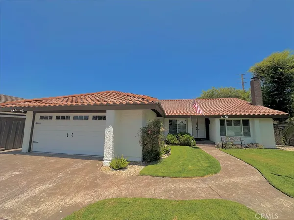 a view of a white house with a yard and potted plants