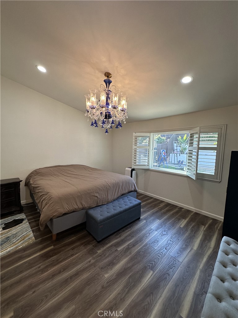 13191 Honeybee Street Moorpark, CA 93021 - Photo 11 of 27 a spacious bedroom with a large bed and a chandelier