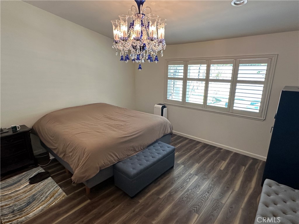 13191 Honeybee Street Moorpark, CA 93021 - Photo 13 of 27 a spacious bedroom with a bed chandelier and a window