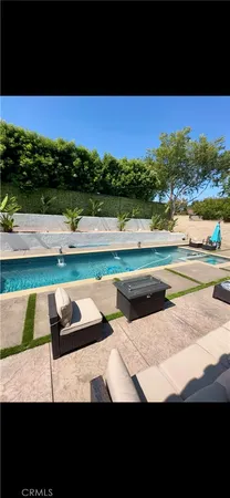 a view of swimming pool with seating area and green space