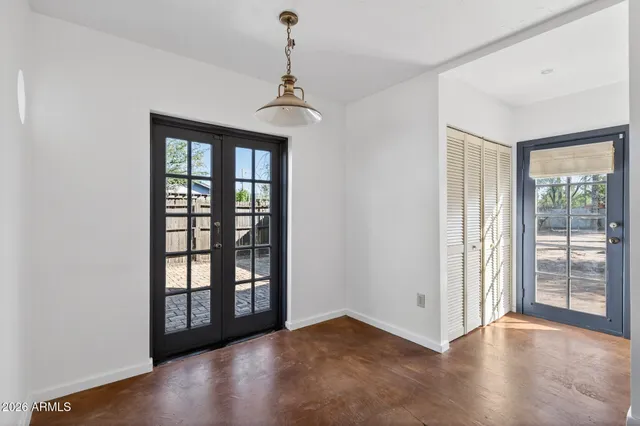 a view of an empty room with window and wooden floor