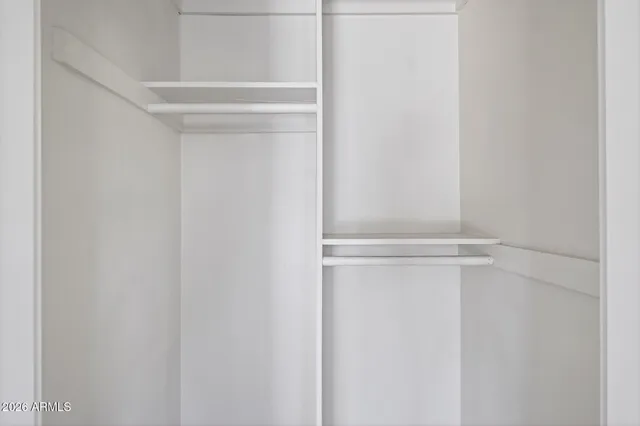 a view of walk in closet with empty racks