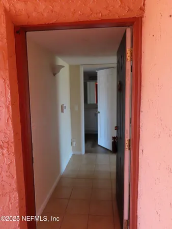 a view of a hallway with closet and bathroom