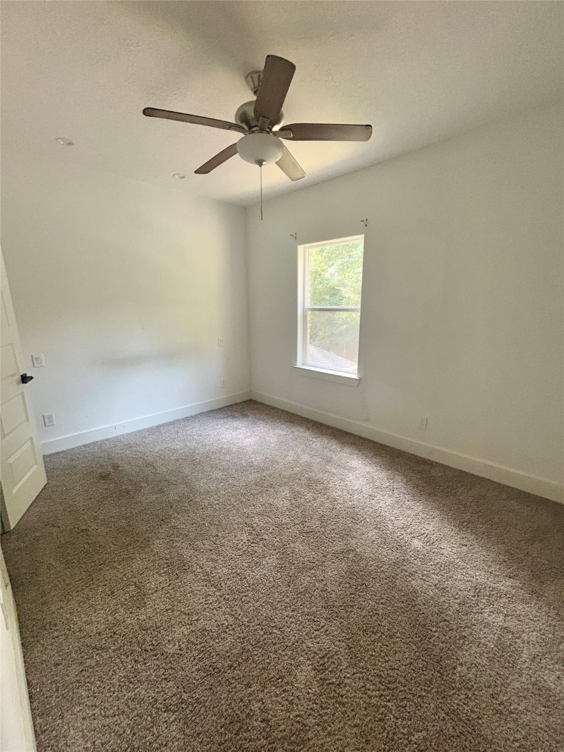 262 Coral Gables Trinity, TX 75862 - Photo 6 of 8 an empty room with a window and a fan