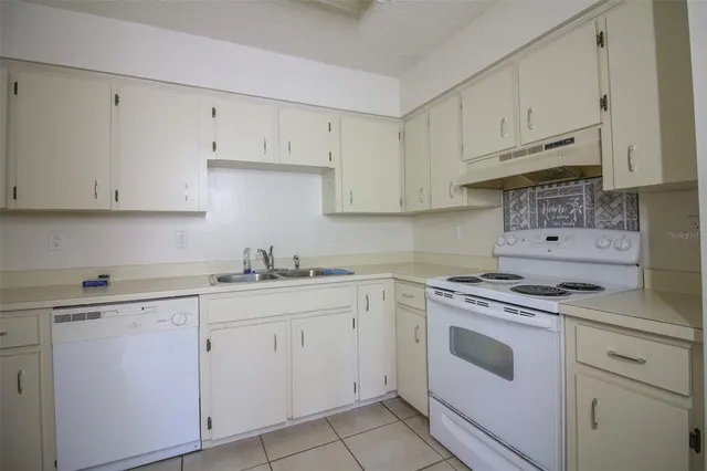 a kitchen with white cabinets and white appliances