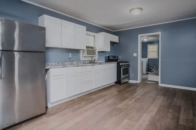 a kitchen with granite countertop cabinets stainless steel appliances and a window
