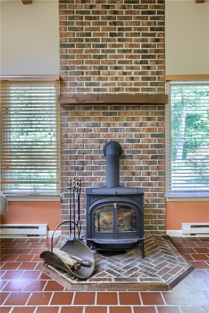 Coldsprings Rd Union Pottstown, PA 19465 - Photo 55 of 71 A striking brick accent wall anchors a cozy wood-burning stove, creating a focal point for the room.