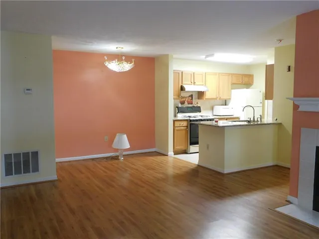 a kitchen with stainless steel appliances granite countertop a sink and a stove with wooden floor