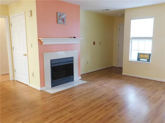 an empty room with wooden floor and fireplace