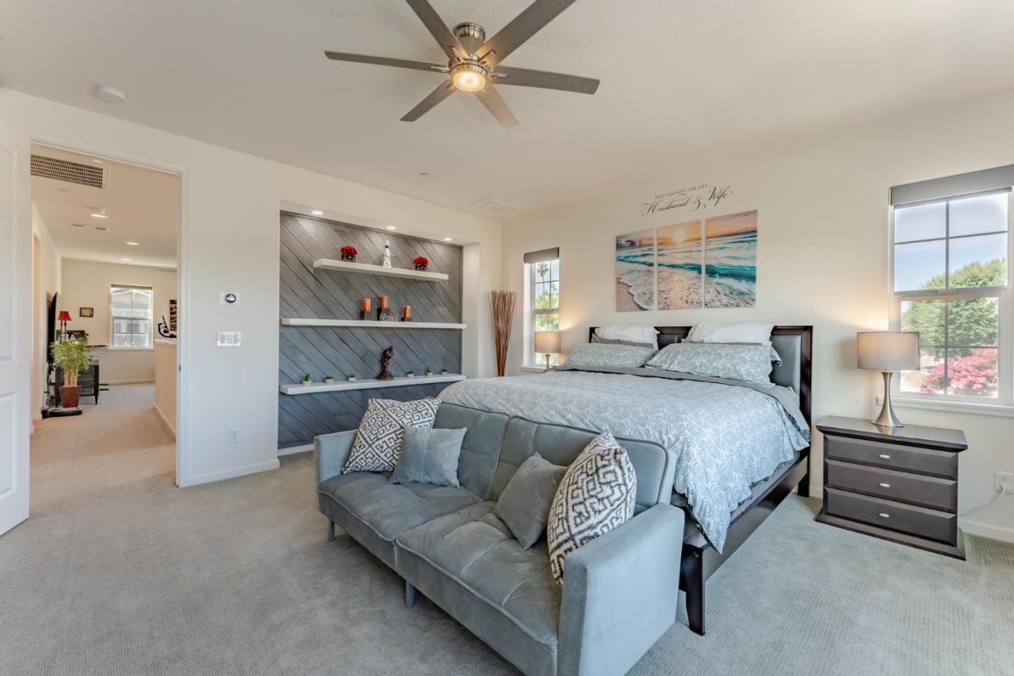 767 Sullivan Way Gilroy, CA 95020 - Photo 18 of 37 a spacious bedroom with a bed a couch and a painting on the wall