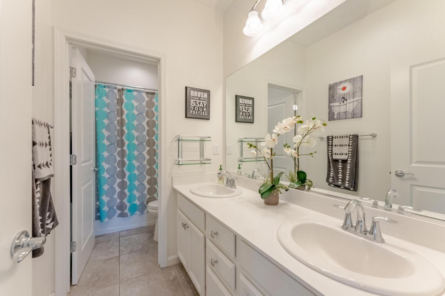 767 Sullivan Way Gilroy, CA 95020 - Photo 22 of 37 a bathroom with double vanity sinks a shower and a mirror