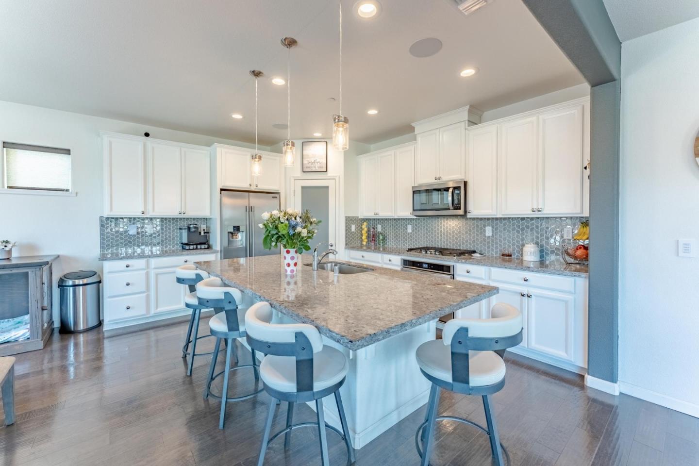 767 Sullivan Way Gilroy, CA 95020 - Photo 8 of 37 a kitchen with kitchen island granite countertop white cabinets and stainless steel appliances