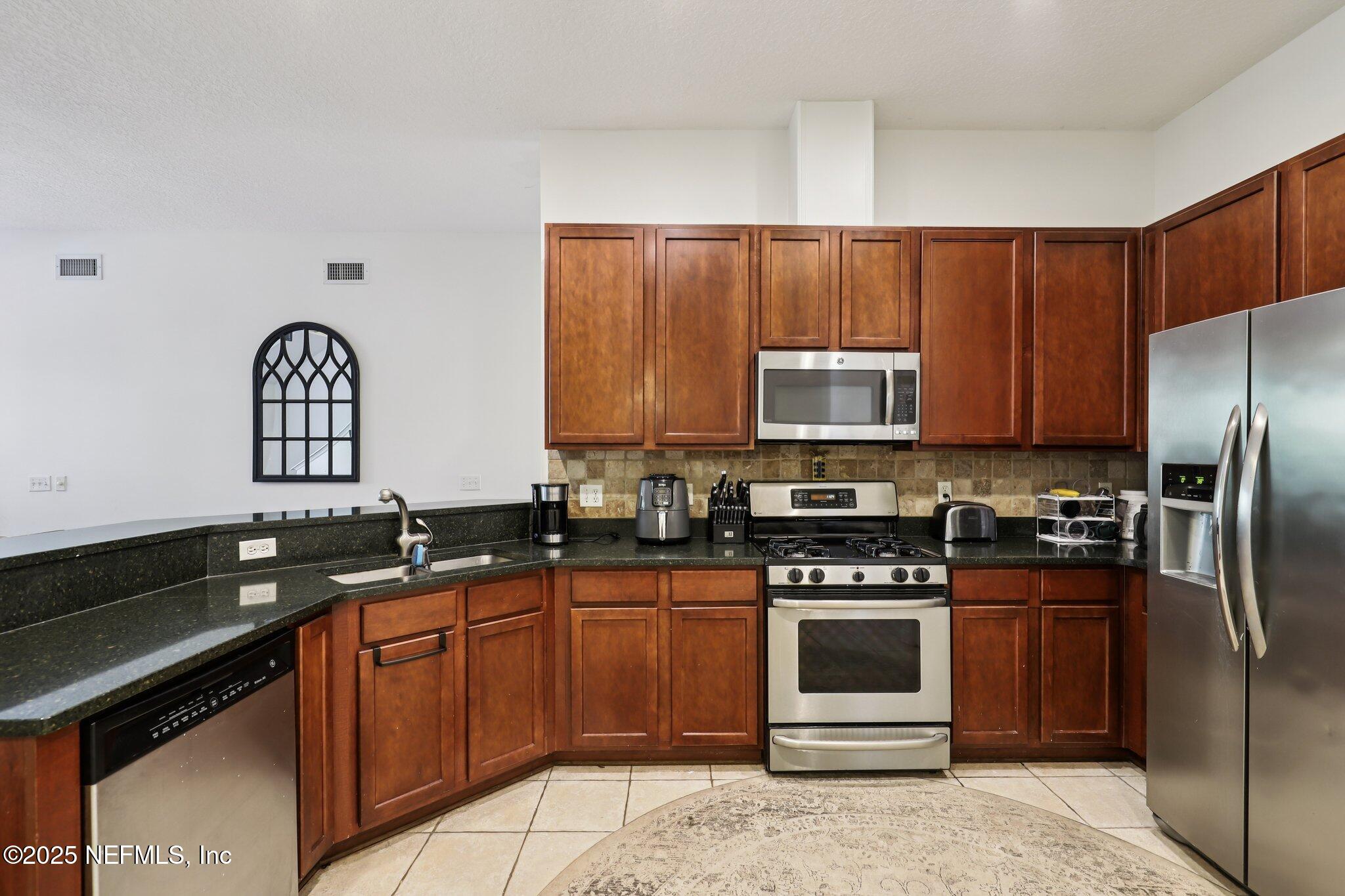 333 Stokes Creek Drive St. Augustine, FL 32095 - Photo 19 of 68 a kitchen with granite countertop a stove a refrigerator and a sink