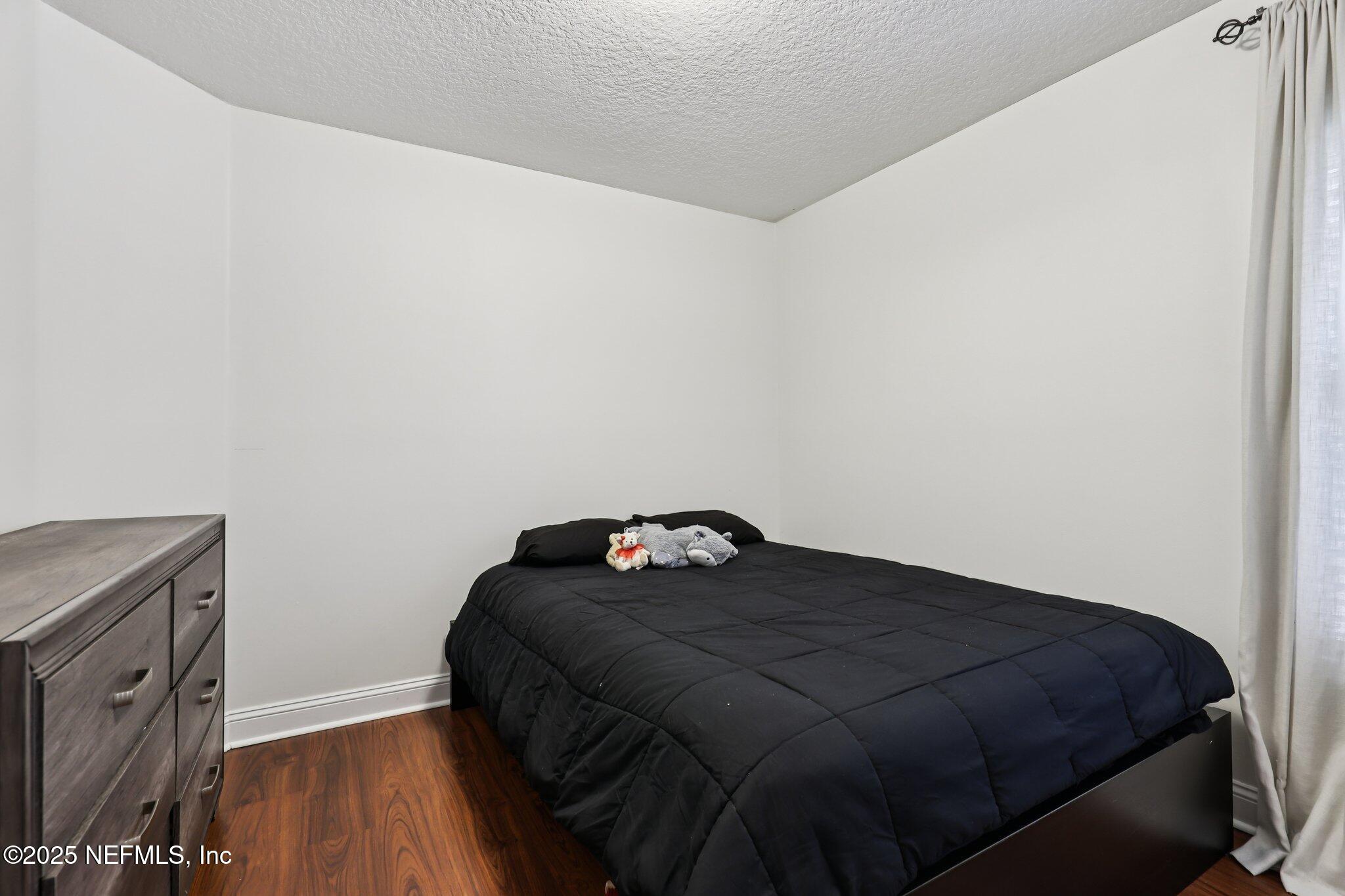 333 Stokes Creek Drive St. Augustine, FL 32095 - Photo 29 of 68 a bedroom with a bed and wooden floor