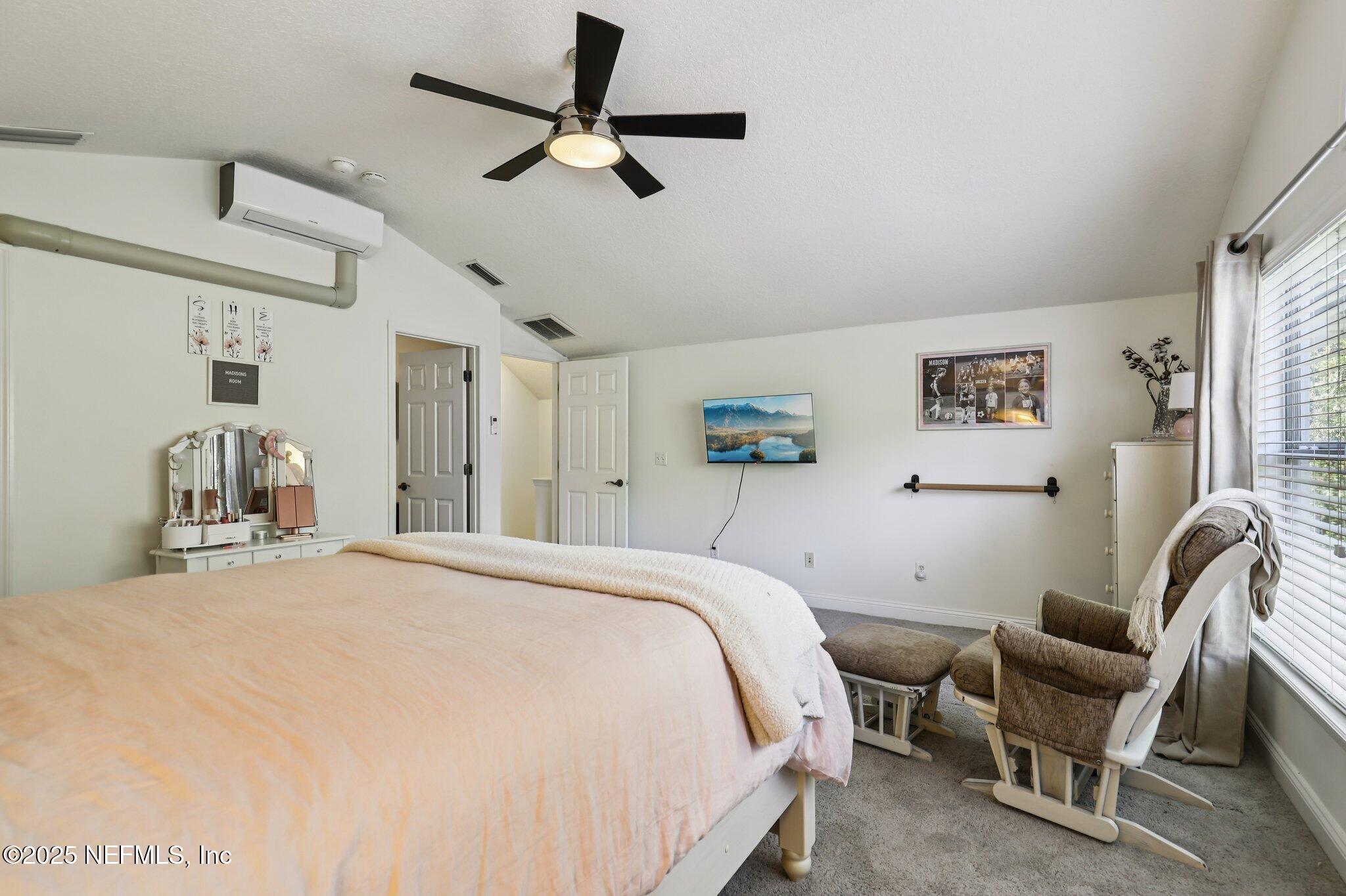 333 Stokes Creek Drive St. Augustine, FL 32095 - Photo 42 of 68 a bedroom with a bed a couch and a chandelier