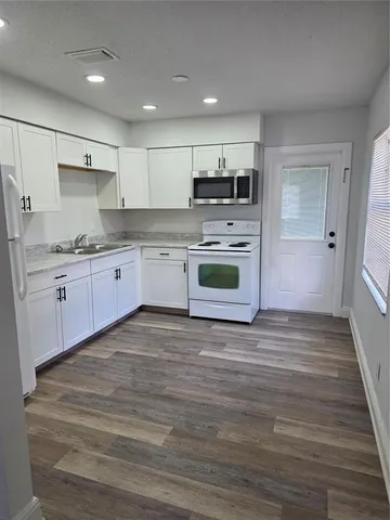 a large kitchen with stainless steel appliances granite countertop a stove a sink and a refrigerator