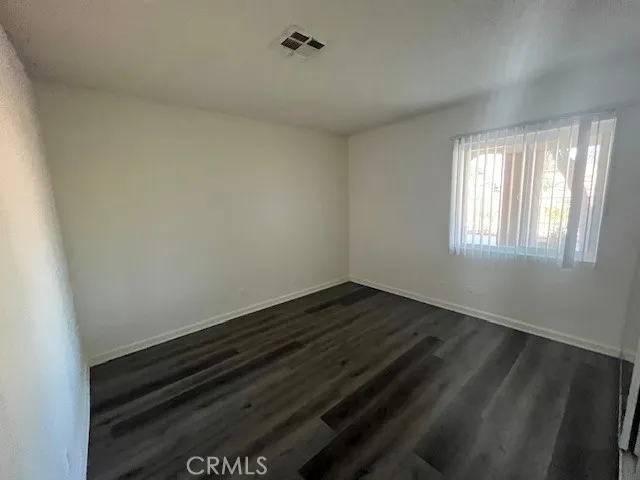 a view of an empty room and wooden floor