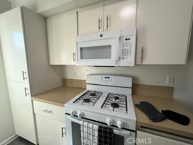 a white stove top oven sitting inside of a kitchen