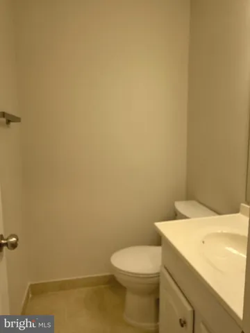 a white toilet sitting next to a white sink and vanity