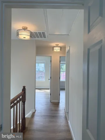 a view of hallway with stairs and wooden floor