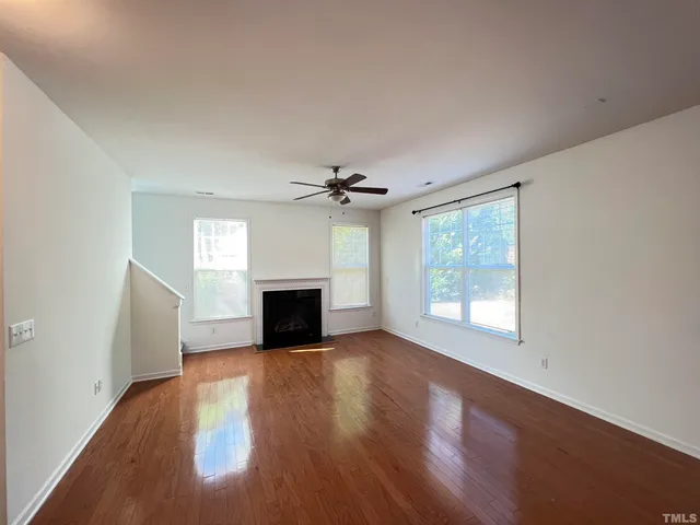an empty room with windows fireplace and windows