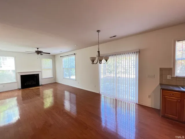 a view of empty room with wooden floor and fireplace