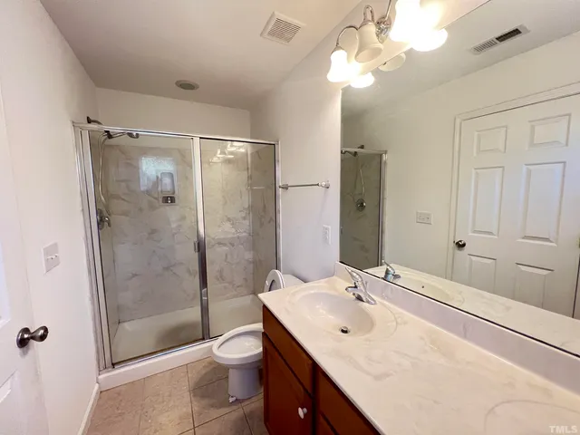 a bathroom with a double vanity sink mirror and toilet